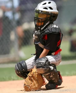 Image of an Elite Fastpitch Catcher wearing a helmet, and full catchers gear