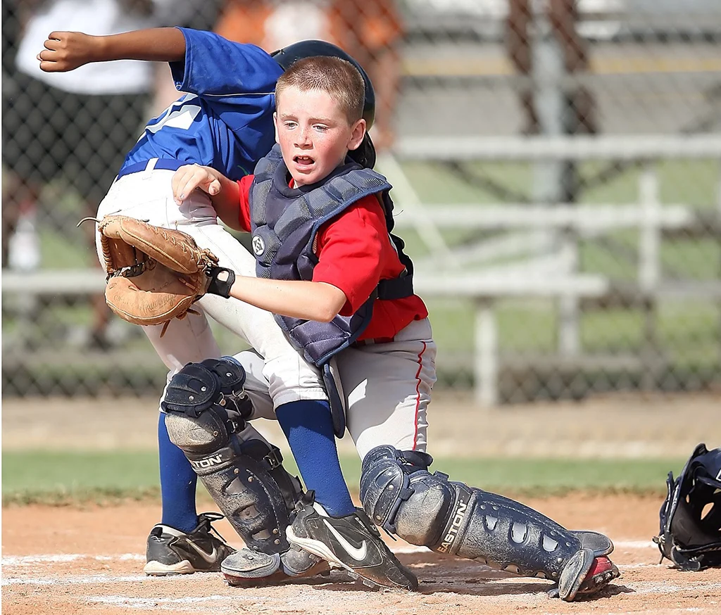 Image of a tough 12U catcher putting his body in front of the plate.