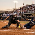 WCWS 2026 elimination game catcher applying tag at home plate — the defining moment of Sunday's Texas Tech vs UCLA game.